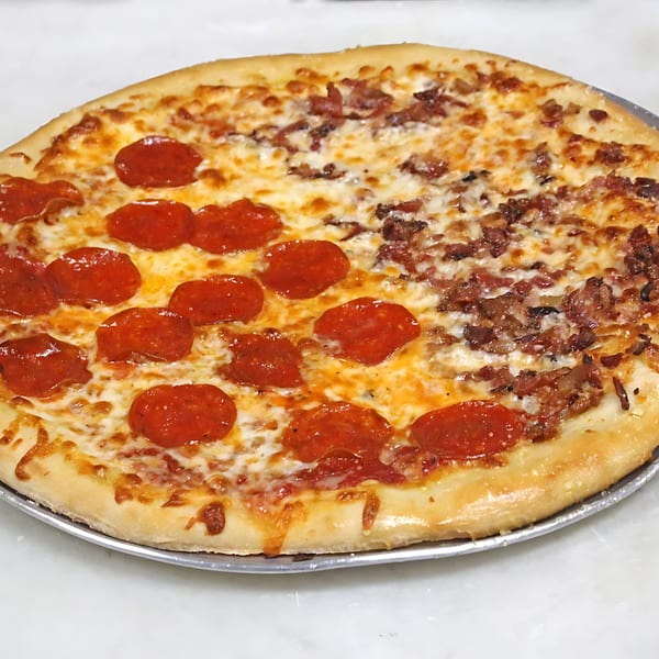 A half-pepperoni, half-bacon pizza from Borinquen Restaurant & Pizzeria on a metal tray.